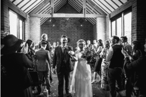 Bride and groom walking down aisle at barn wedding ceremony in Stratford