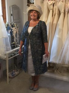 Mother of the bride wearing her bespoke, tailored jacket in bridal boutique in Stratford Upon Avon