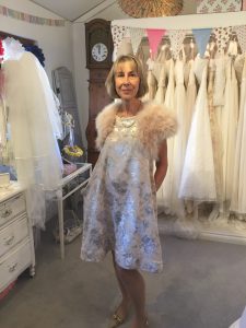 Mother of the bride wearing her bespoke, tailored dress and bolero in bridal boutique in Stratford Upon Avon