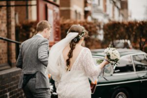 Bespoke, lace wedding dress with low back and sleeves and a long train. Wedding dress designed and created by Lola and Em bridal designers from Warwickshire in association with Boho Bride Boutique in Stratford Upon Avon