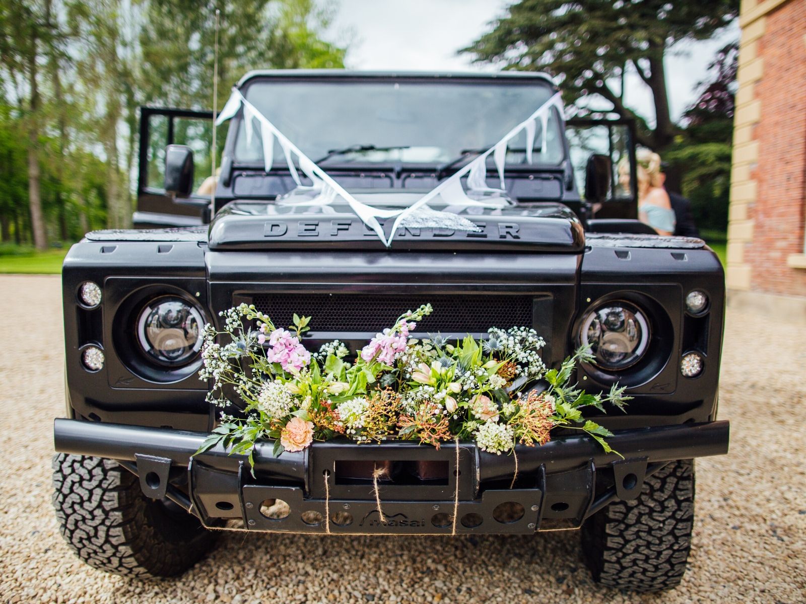 Land Rover wedding transport with bunting and flowers