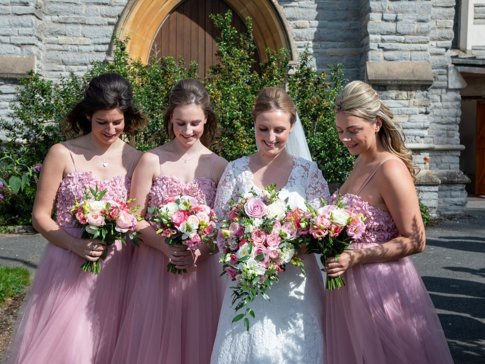 Boho bride with her bridesmaids in blush pink wedding dresses