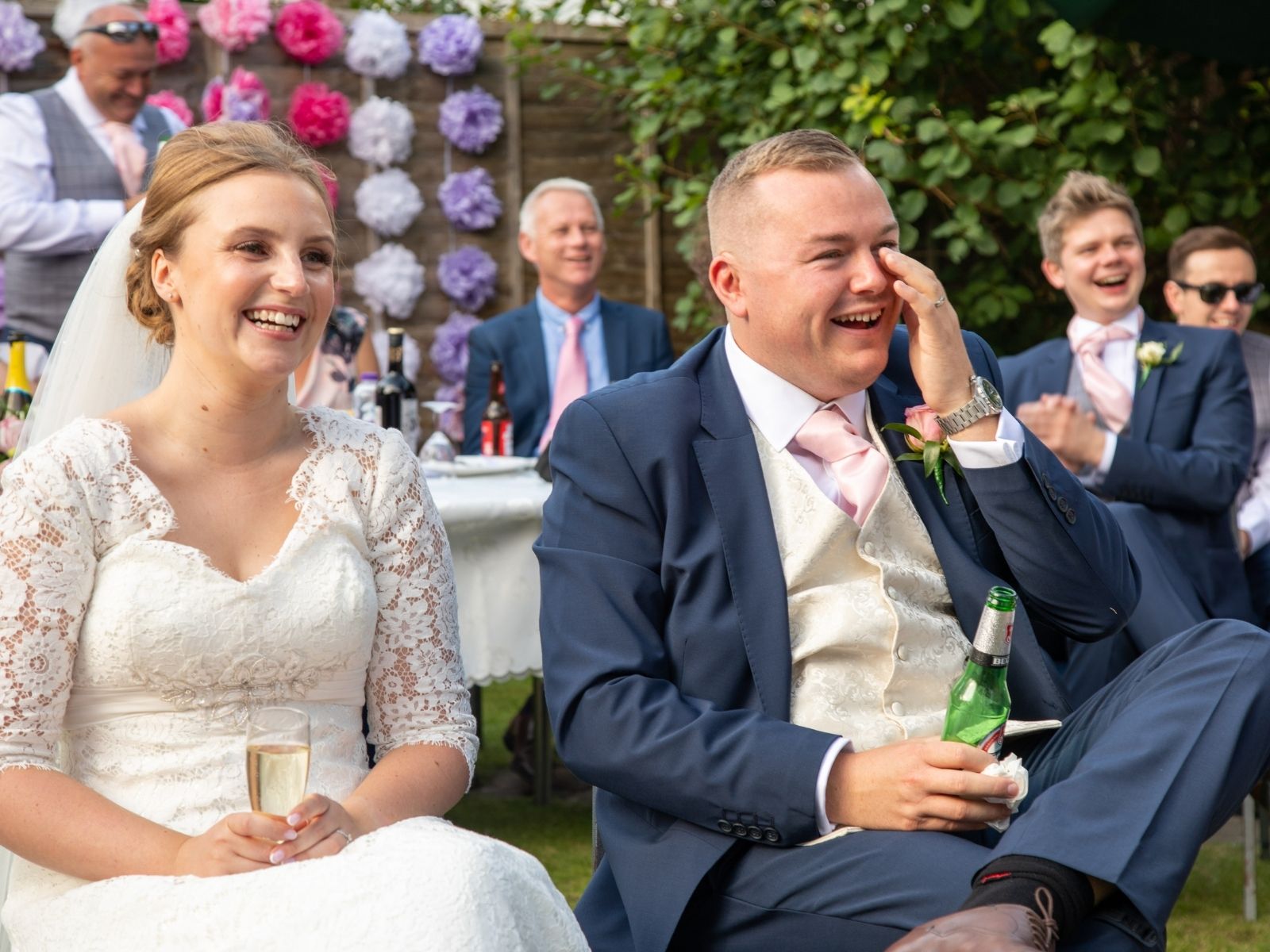 Bride and groom laughing at the speeches guests gave on their wedding day